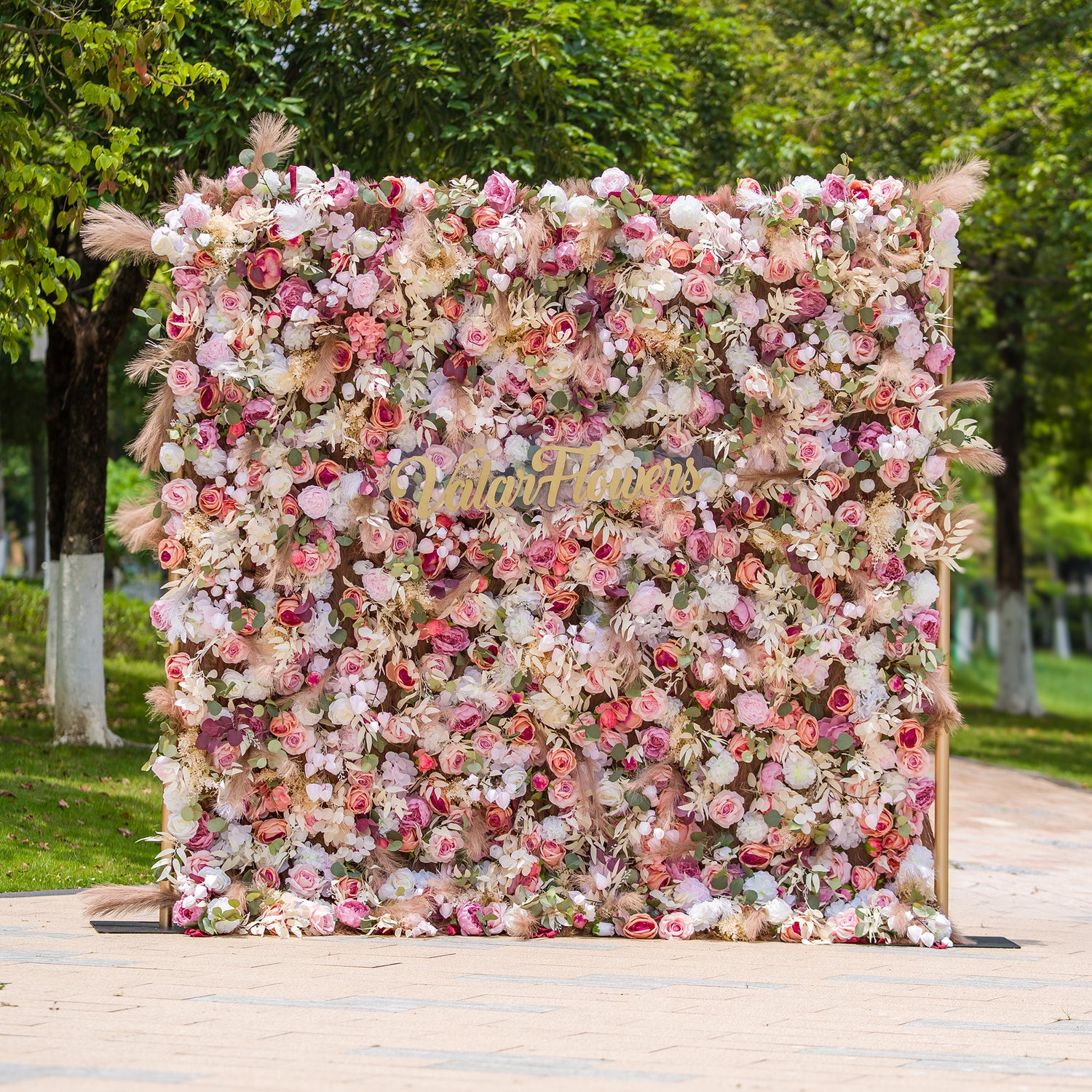 This photo showcases a 2.4x2.4m floral backdrop made by ValarFlowers, densely packed with an array of roses, peonies, and other blooms in soft pinks, whites, and hints of peach. Interspersed with green foliage and pampas grass, it exudes a romantic and elegant vibe. Ideal for events such as a “Romantic Blush” wedding or a spring - themed garden party, it creates a dreamy atmosphere.