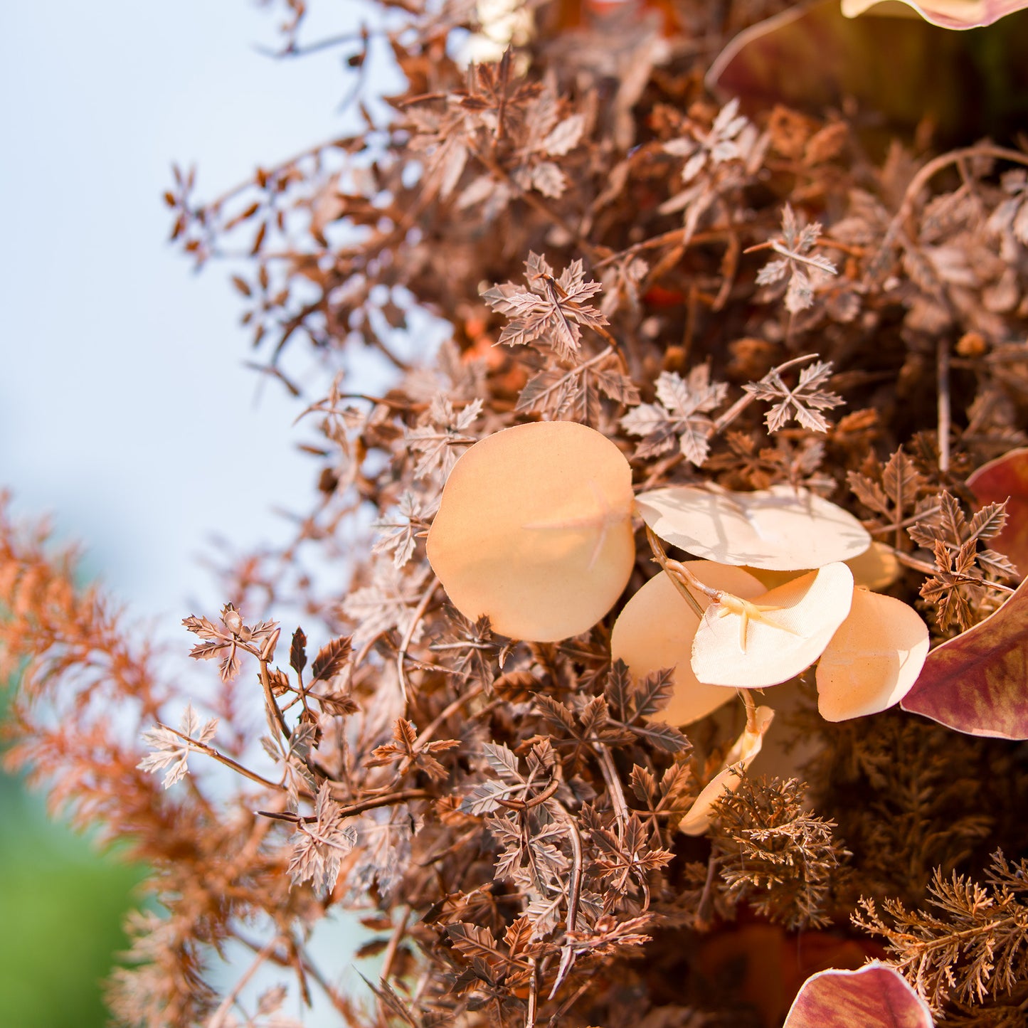 This photo features a textured arrangement of autumn - inspired foliage, including eucalyptus leaves in warm, earthy tones and delicate, dried - look branches. Ideal for events like a “Harvest Harmony” wedding or an autumnal corporate gathering, it exudes rustic charm, setting a cozy, seasonal atmosphere. 