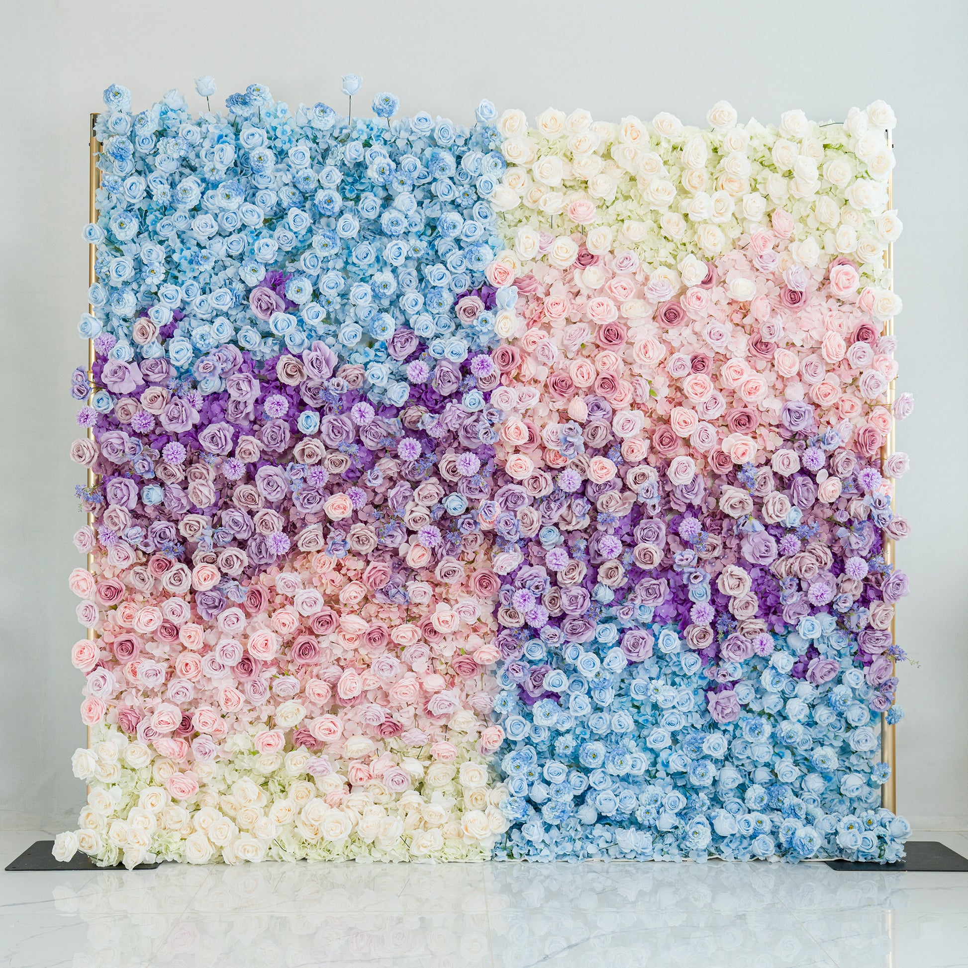 This stunning floral wall features a gradient of blooms—white roses, pink peonies, purple hydrangeas, and blue delphiniums. The color theme, transitioning from cool blues to soft pastels and whites, creates a dreamy, elegant vibe. Perfect for weddings, galas, or upscale events, it blends natural beauty with a polished aesthetic, ideal as a photo backdrop or decorative centerpiece. 
