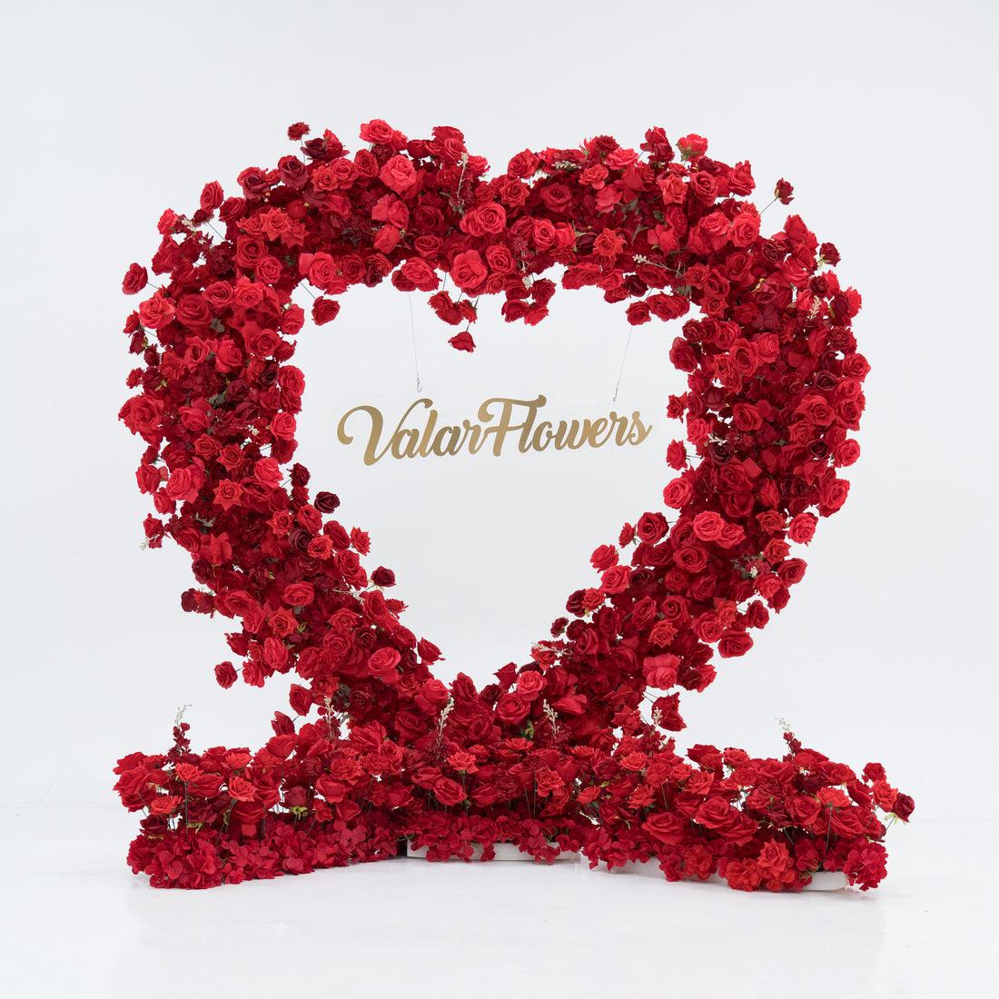 A heart - shaped flower arrangement made of red roses forms a large "2" shape. In the center, the gold - lettered "Valar Flowers" stands out. The vibrant red blooms create a romantic, eye - catching display, perfect for celebrating love or special occasions.