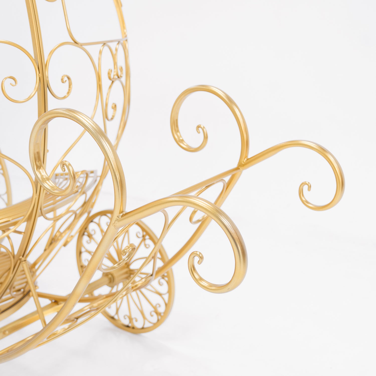 A close - up of a golden, ornate metal structure—part of a Cinderella - style carriage. Features elegant, swirling scrollwork and curved lines. The shimmering gold finish adds a fairy - tale charm, perfect for themed decorative displays. 