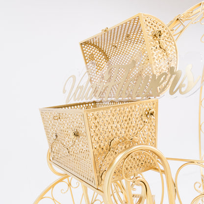 A close - up of a gold, ornate metal trunk with latticework, part of a Cinderella - style carriage. The lid is open, revealing a clear acrylic “ValarFlowers” sign inside. Decorative floral motifs and clasps enhance its fairy - tale charm, perfect for themed displays. 