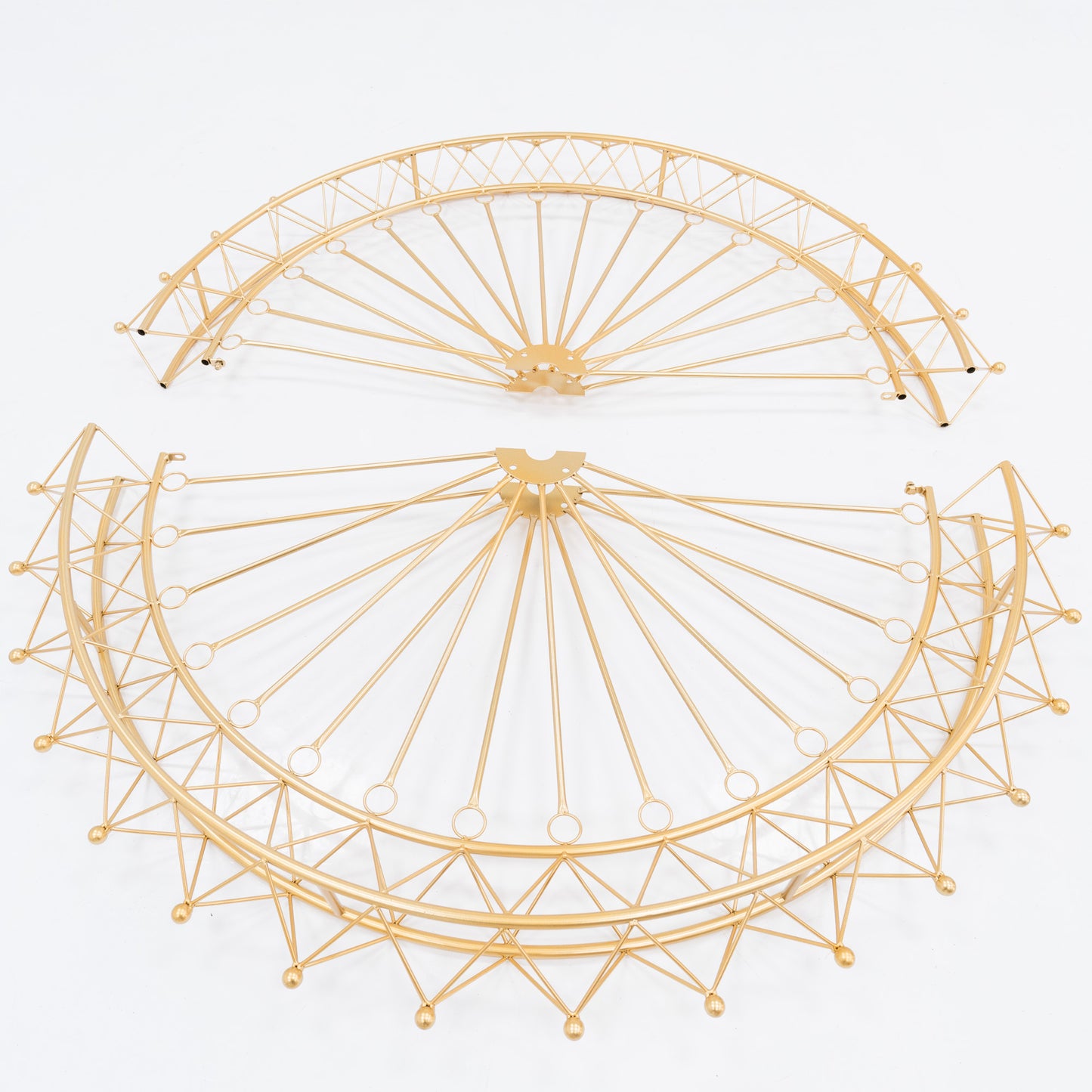 Two golden, semi - circular metal frames, parts of a Ferris wheel decoration. Intricate spoke and lattice designs create a delicate, decorative structure. The shimmering gold finish adds elegance, ideal for assembling themed event decor. 