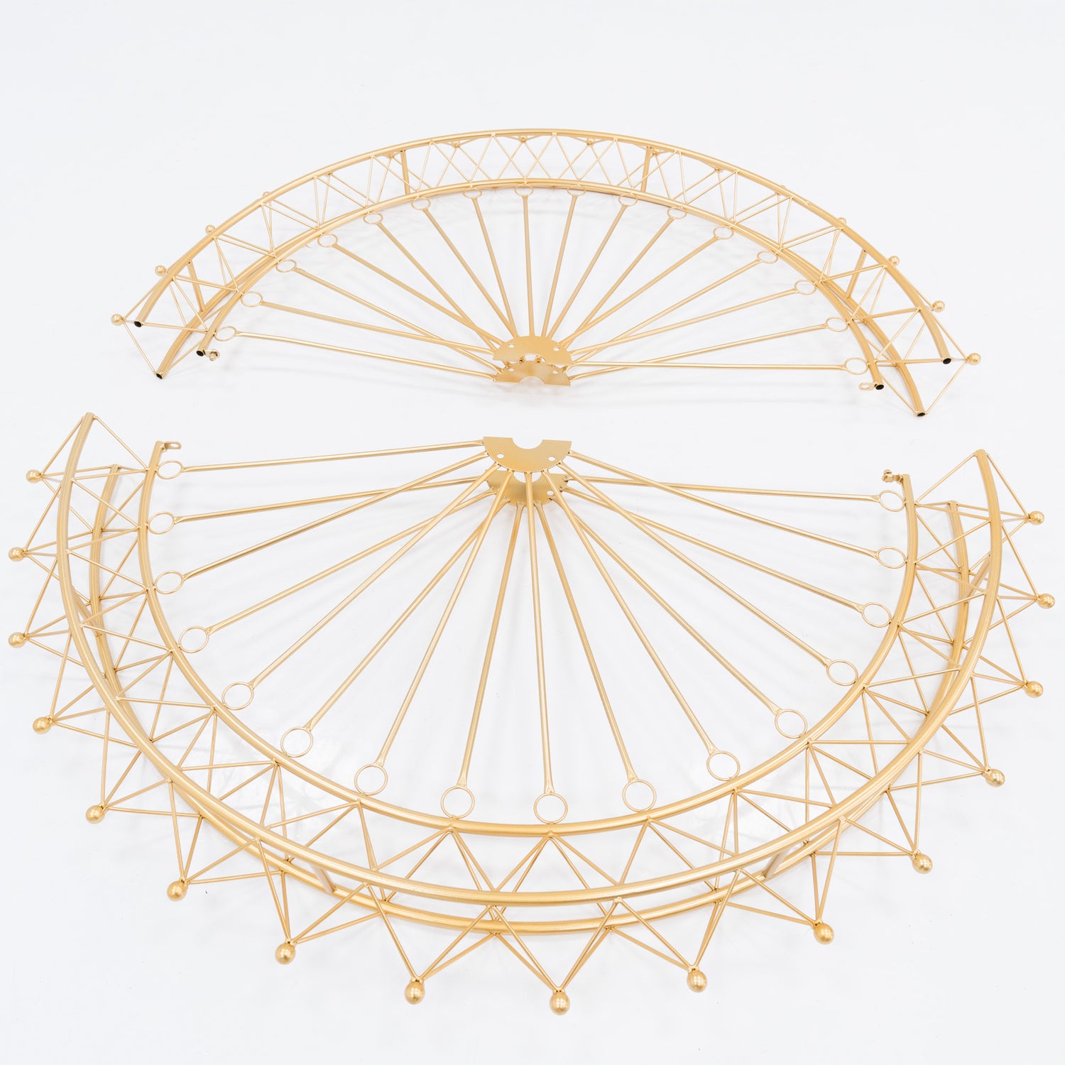 Two golden, semi - circular metal frames, parts of a Ferris wheel decoration. Intricate spoke and lattice designs create a delicate, decorative structure. The shimmering gold finish adds elegance, ideal for assembling themed event decor. 