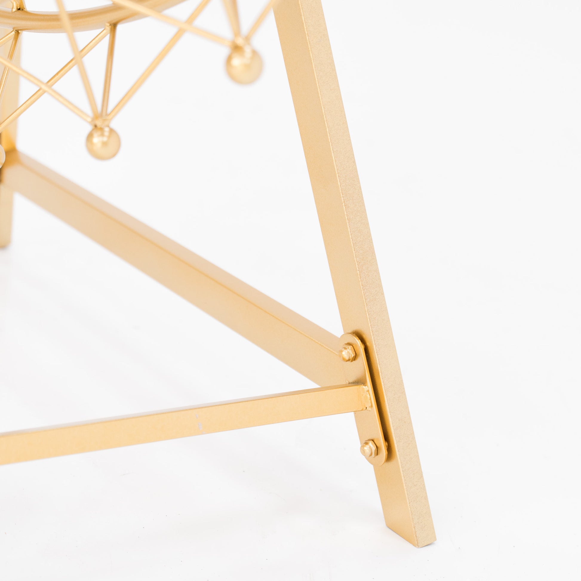 Close - up of a golden metal frame joint, likely part of a decorative Ferris wheel stand. Bolts secure the triangular frame, showcasing sturdy, elegant craftsmanship. The shimmering gold finish adds a touch of sophistication, ideal for event decor. 