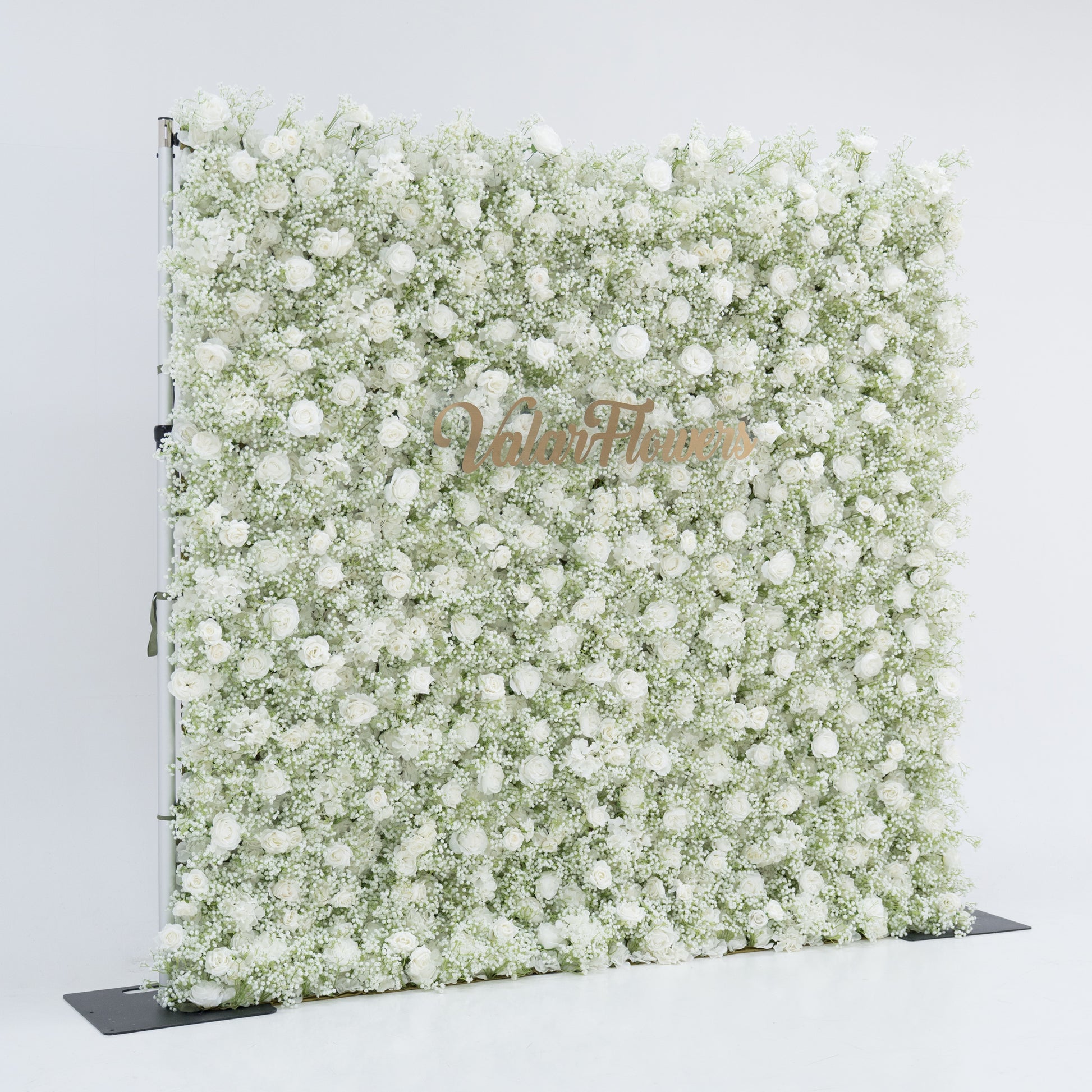 This image features a large, square floral wall densely covered with white flowers, including baby's breath and small blooms. "Valar Flowers" is displayed in elegant, golden text. Set against a plain white background, the wall exudes a pure, elegant, and refined atmosphere, perfect for decorative purposes in events or as a stylish backdrop, highlighting the beauty and craftsmanship of Valar Flowers.
