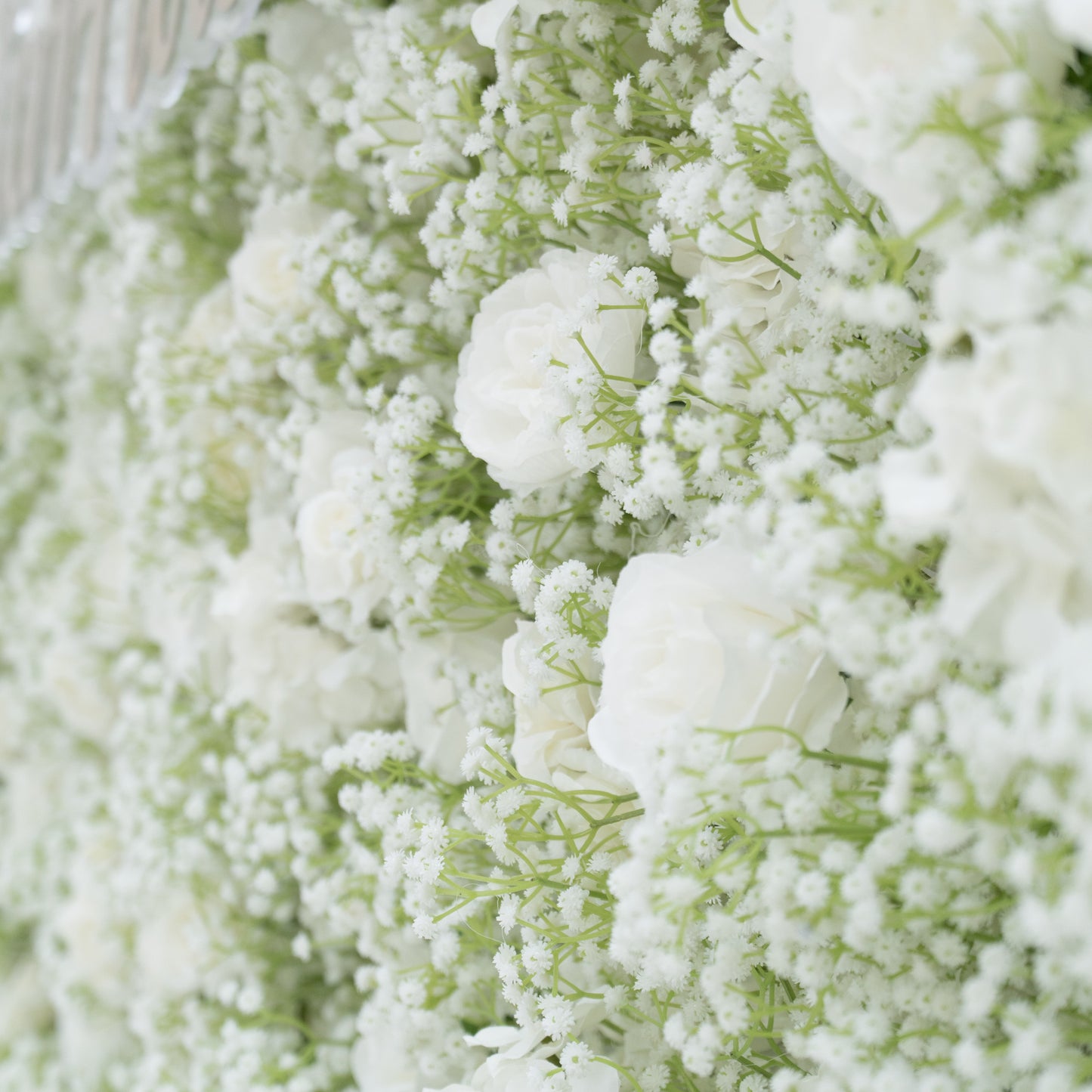 This image features a lush arrangement of white flowers, including roses and baby's breath. The blooms are densely clustered, creating a soft, elegant, and pure visual effect. Set against a light - colored background, the flowers exude a sense of tranquility and beauty, perfect for decorative purposes in events or as a symbol of innocence and grace.