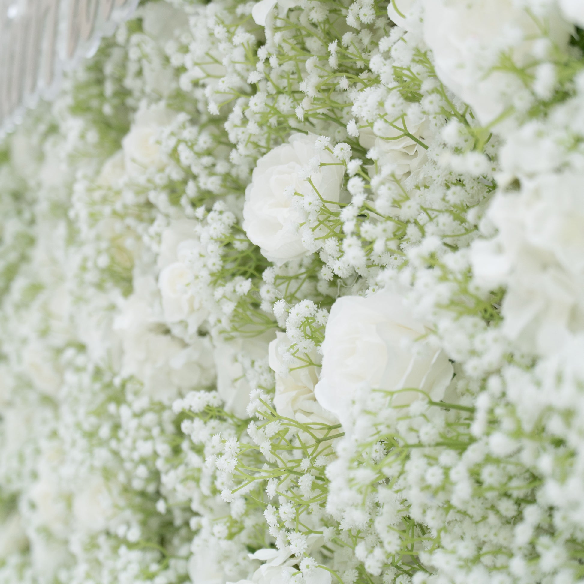 This image features a lush arrangement of white flowers, including roses and baby's breath. The blooms are densely clustered, creating a soft, elegant, and pure visual effect. Set against a light - colored background, the flowers exude a sense of tranquility and beauty, perfect for decorative purposes in events or as a symbol of innocence and grace.