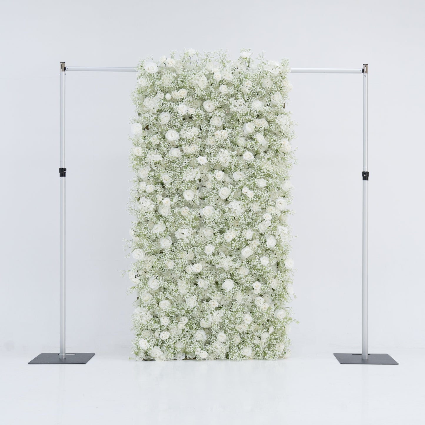 This image showcases a 4x8ft floral wall by Valar Flowers, densely adorned with white roses and baby's breath. The lush, pure white blooms create a stunning, elegant, and serene visual. Suspended between two sleek metal stands against a plain white background, the wall exudes sophistication and natural beauty, perfect for events or as a stylish backdrop, highlighting the brand's craftsmanship and the delicate allure of the floral arrangement.