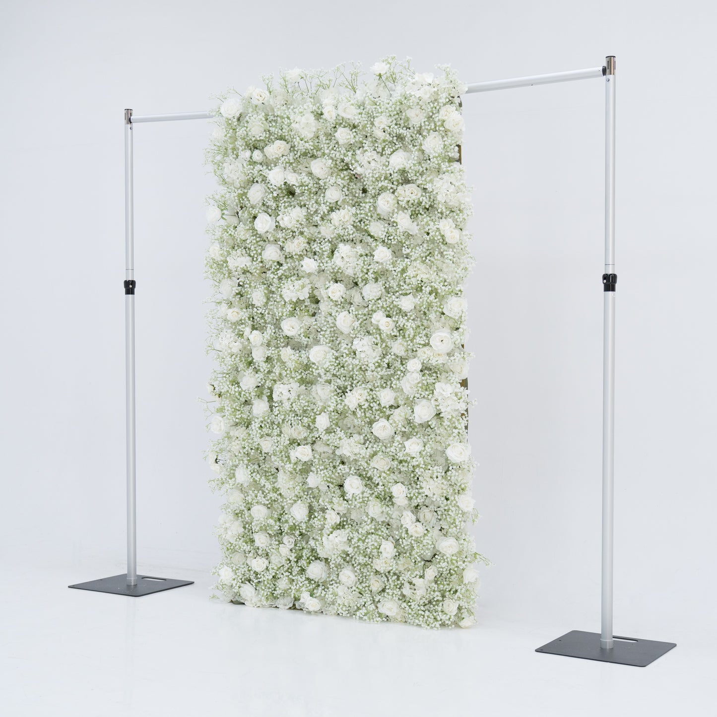 This image features a 4x8ft floral wall by Valar Flowers, densely covered with white roses and baby's breath. Suspended between two sleek metal stands against a plain white background, the lush, pure white blooms create an elegant and serene visual. The arrangement exudes sophistication and natural beauty, making it perfect for events or as a stylish backdrop, highlighting the brand's craftsmanship and the delicate allure of the floral display.