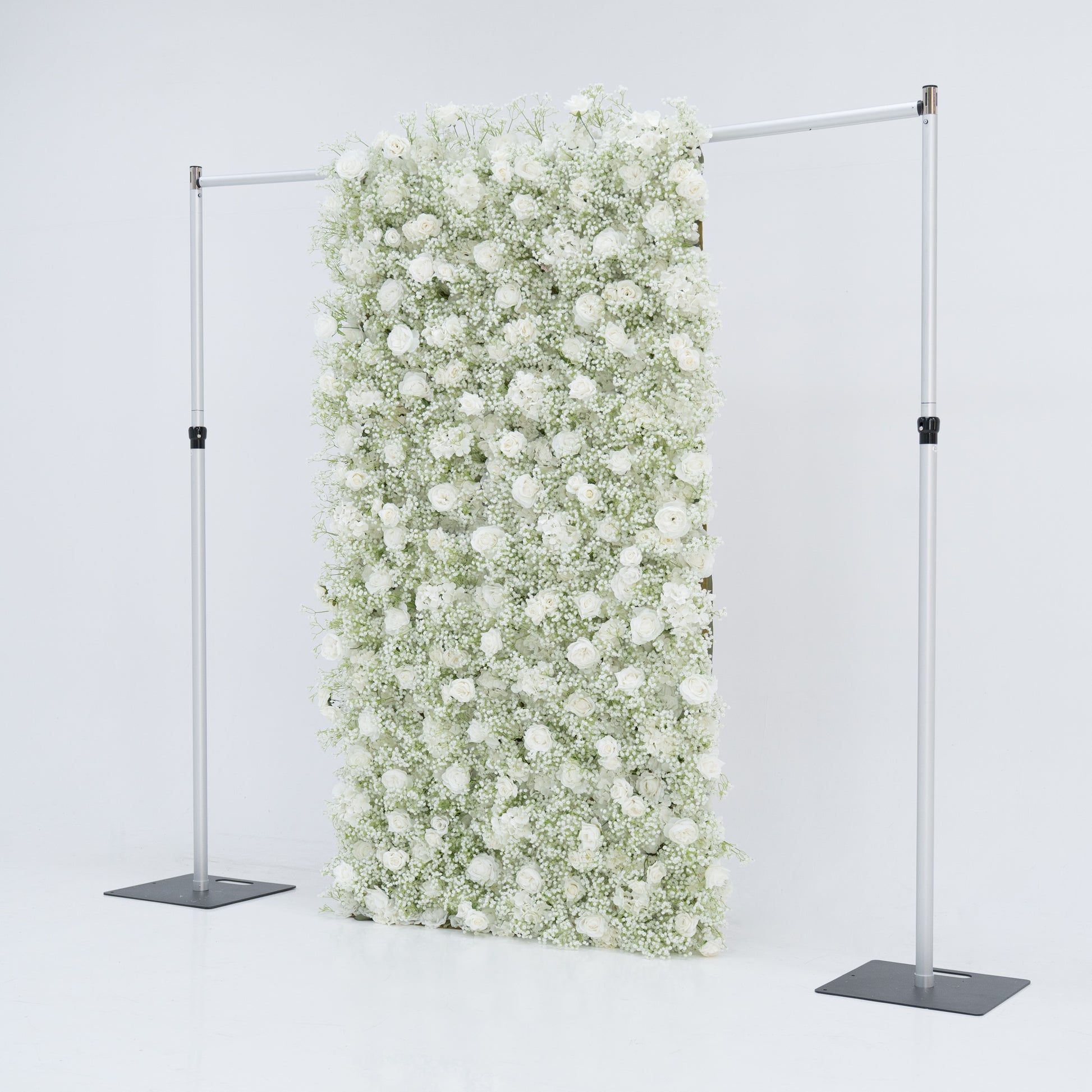 This image features a 4x8ft floral wall by Valar Flowers, densely covered with white roses and baby's breath. Suspended between two sleek metal stands against a plain white background, the lush, pure white blooms create an elegant and serene visual. The arrangement exudes sophistication and natural beauty, making it perfect for events or as a stylish backdrop, highlighting the brand's craftsmanship and the delicate allure of the floral display.