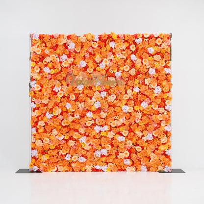 This image showcases a vibrant floral backdrop by Valar Flowers, featuring a dense arrangement of artificial flowers in warm shades of orange, peach, and hints of pink. The textured display exudes energy and warmth, with the brand’s name elegantly integrated. Set against a plain white indoor background, it’s perfect for adding a bold, nature-inspired element to events or interiors.