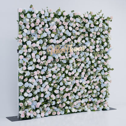 This image showcases a vibrant floral backdrop by Valar Flowers, set against a plain white indoor background. It features a dense arrangement of artificial flowers in various shades of blue, light blue, and pink, with the brand’s name elegantly integrated in gold. Exuding elegance, it’s perfect for adding a sophisticated, nature-inspired element to events or interiors, highlighting Valar Flowers’ craftsmanship in detailed, eye-catching decor.