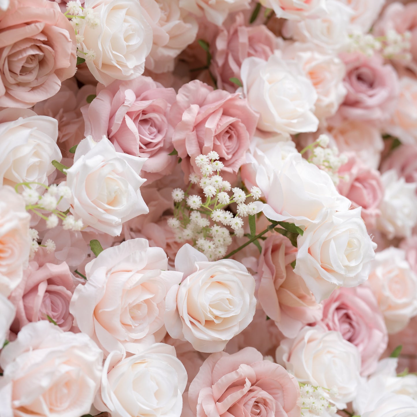 A close-up of a Valar Flowers floral wall, densely packed with a romantic blend of creamy white, soft blush, and dusty pink roses, interspersed with delicate white baby's breath. The layered, textured blooms create a dreamy, elegant aesthetic, ideal for luxury wedding backdrops, bridal showers, and romantic event decor, radiating timeless charm and sophistication.