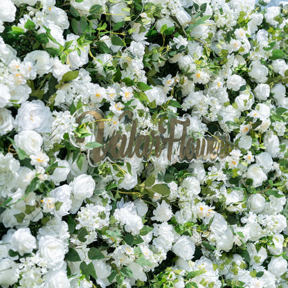This close-up showcases Valar Flowers’ premium artificial white flower wall, featuring lush, hyper-realistic roses, peonies, and delicate filler blooms paired with vibrant green foliage. Centered with the metallic "ValarFlowers" logo, the dense, layered design highlights lifelike petals and soft textures, creating an elegant, maintenance-free display. Ideal for weddings, photo booths, and luxury events, this durable decor offers a clean, romantic aesthetic perfect for professional styling.