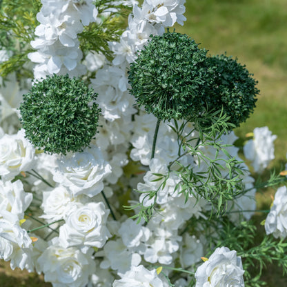 This close-up highlights the intricate details of Valar Flowers’ premium artificial floral arrangement, showcasing three lush green spherical accents paired with realistic white roses, hydrangeas, and delicate green foliage. The shallow depth of field emphasizes the texture of the greenery and soft petals, creating a lifelike, romantic aesthetic. Maintenance-free and durable, this elegant display is ideal for weddings, photo booths, and luxury events, offering a clean, timeless look perfect for events.