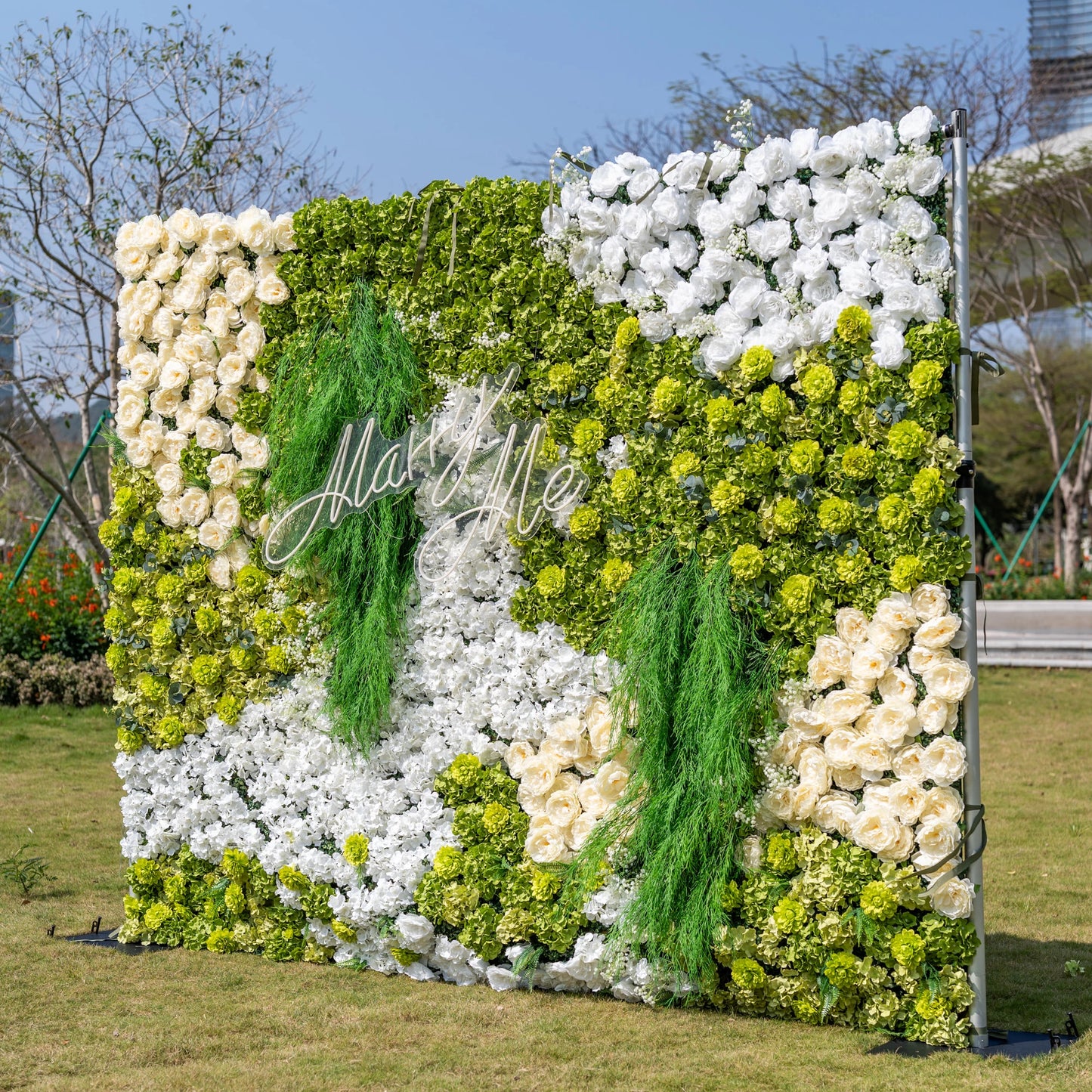 This is a stunning 10x8ft artificial flower wall backdrop by Valar Flowers, featuring a lush, nature-inspired design with vibrant green hydrangeas, cascading foliage, soft ivory roses, and crisp white blooms. Centered with a custom "Marry Me" neon sign, this reusable, maintenance-free display creates a romantic focal point, ideal for outdoor weddings, proposals, photo booths, and luxury events, offering long-lasting beauty for professional decor.