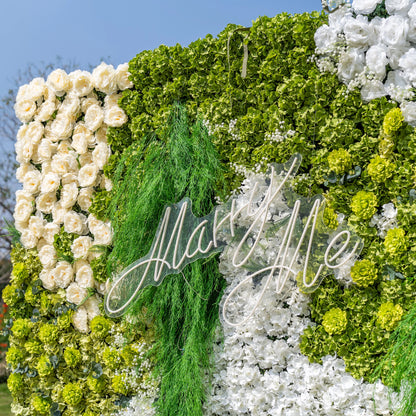 This close-up highlights Valar Flowers’ premium artificial floral wall, featuring lush green hydrangeas, cascading foliage, soft ivory roses, and crisp white blooms, with a glowing "Marry Me" neon sign as the centerpiece. The hyper-realistic petals and dense, layered greenery create a romantic, maintenance-free display. Ideal for proposals, weddings, photo booths, and luxury events, this decor offers an elegant, nature-inspired aesthetic perfect for special occasions.