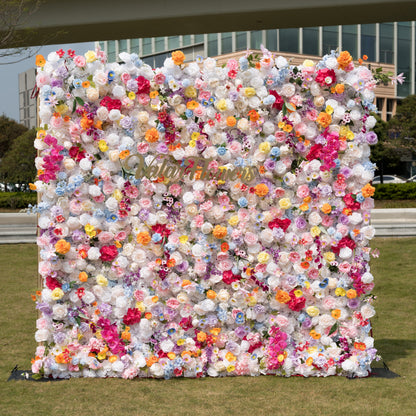Valar Flowers premium vibrant mixed artificial flower wall backdrop, a dense, lush floral panel bursting with a rainbow of lifelike blooms—roses, poppies, carnations, orchids, and filler flowers in pink, orange, yellow, blue, purple, and white. This stunning, romantic backdrop is perfect for outdoor weddings, proposals, engagement parties, photo booths, and luxury event decor.