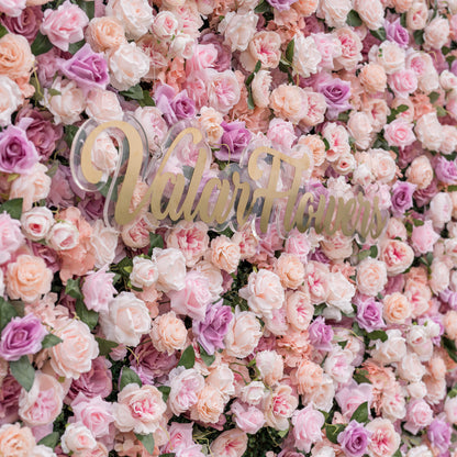 Low-angle close-up of Valar Flowers artificial flower wall emphasizing sculptural depth of blush roses peach peonies and ivory hydrangeas on fabric base with dreamy defocused garden background for romantic wedding ceremonies and sweetheart table backdrops