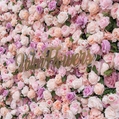 Dreamy close-up of Valar Flowers silk flower wall with blush pink dusty rose peach and lavender roses accented by layered peony blooms in soft romantic blur evoking fine art for bridal portraits and luxury ceremony backdrops