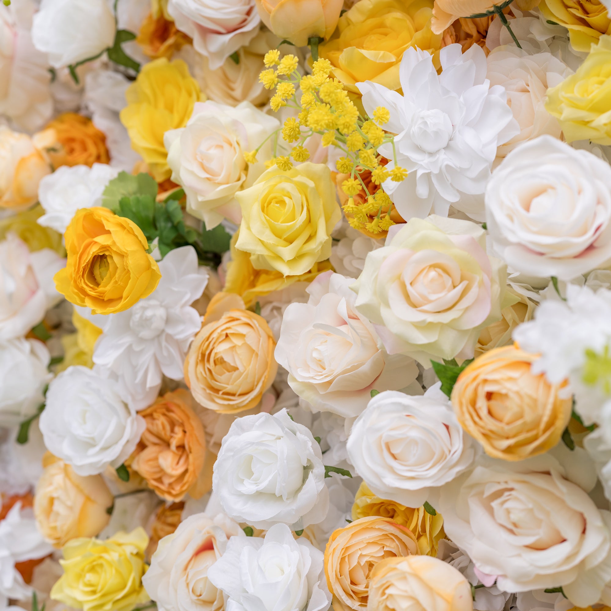 Dreamy close-up of Valar Flowers silk flower wall: crisp white, sunlit yellow, and warm apricot roses with yellow filler sprigs in soft romantic blur. Fine art backdrop for bridal portraits and luxury ceremonies.
