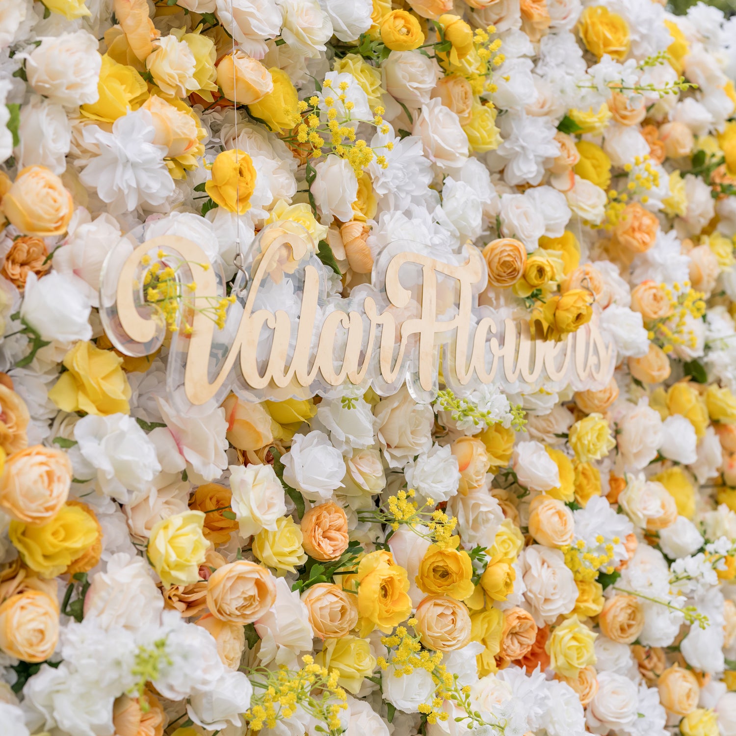 Valar Flowers wall close-up: laser-cut ValerFlowers wooden sign on acrylic among white and yellow roses with delicate accents. Rich texture and artisanal charm for rustic-chic weddings and garden bridal shower displays.