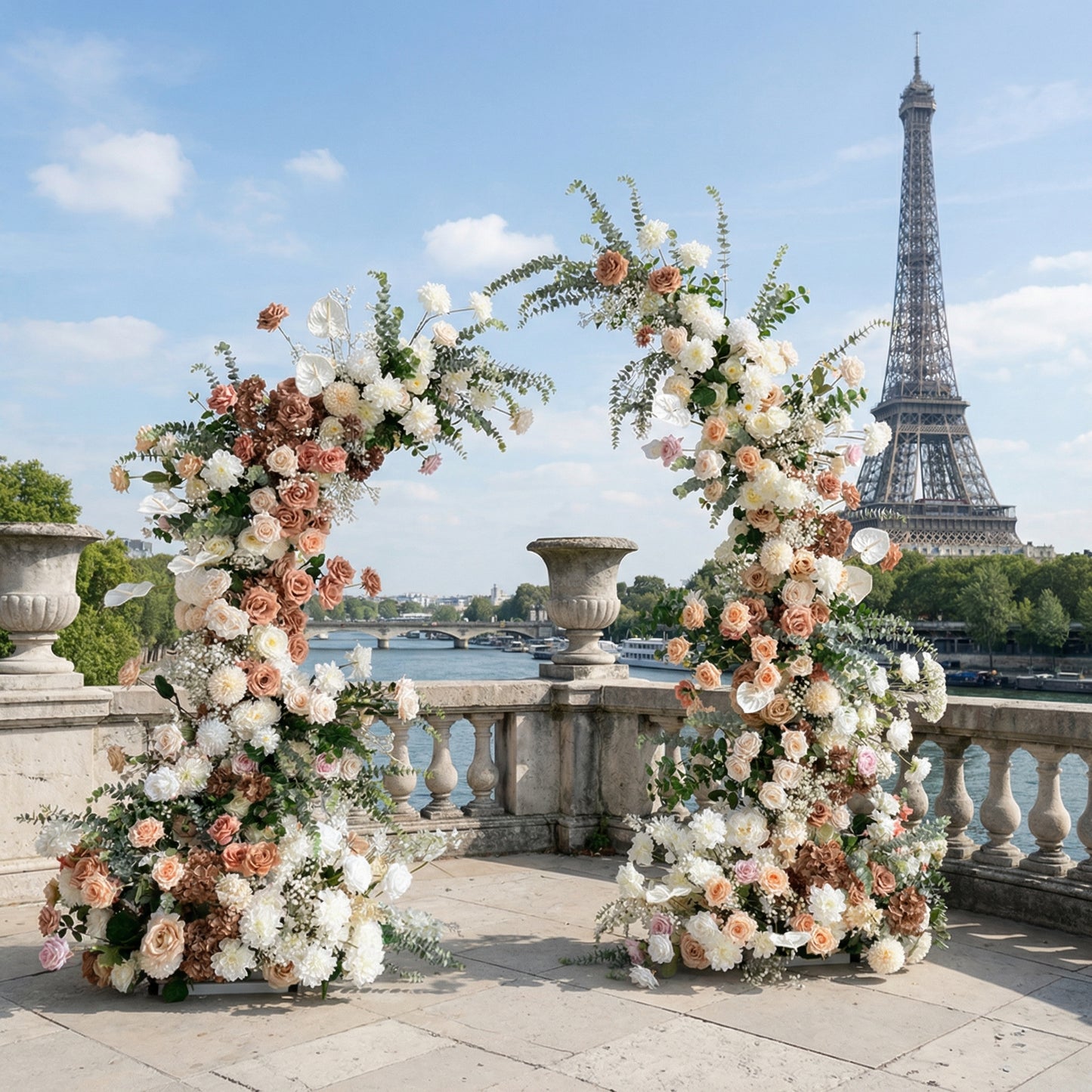 A romantic, asymmetrical floral arch from Valar Flowers, crafted with a soft, warm palette of blush pink, terracotta, and creamy white blooms—including roses, peonies, and delicate baby's breath—intertwined with silvery eucalyptus and lush greenery. Set on a sunlit Parisian riverside terrace with the iconic Eiffel Tower in the background, it creates a dreamy, elegant, and sophisticated atmosphere perfect for luxury weddings and editorial photoshoots.
