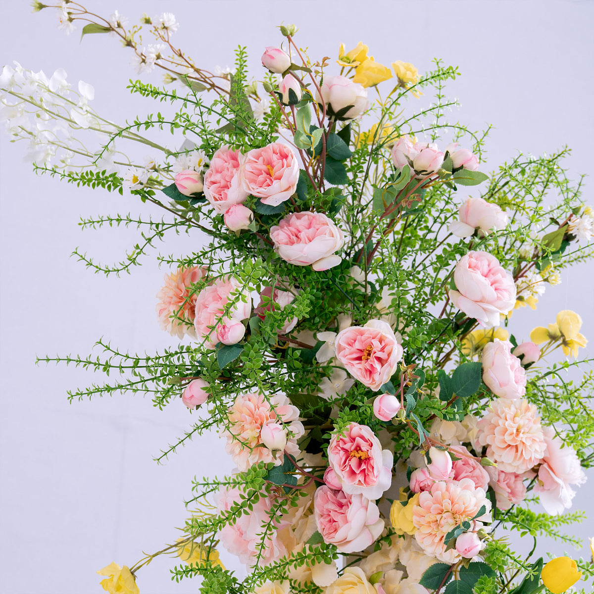 This photo features a lush arrangement of artificial flowers. It includes soft pink roses, peach - toned peonies, small white blossoms, and sunny yellow blooms, all interspersed with delicate green foliage. The pastel hues and varied textures create a romantic, garden - inspired vibe, perfect for adding an elegant, natural touch to weddings, events, or home decor. The realistic faux flowers offer long - lasting beauty, ideal for creating a charming and polished aesthetic. 