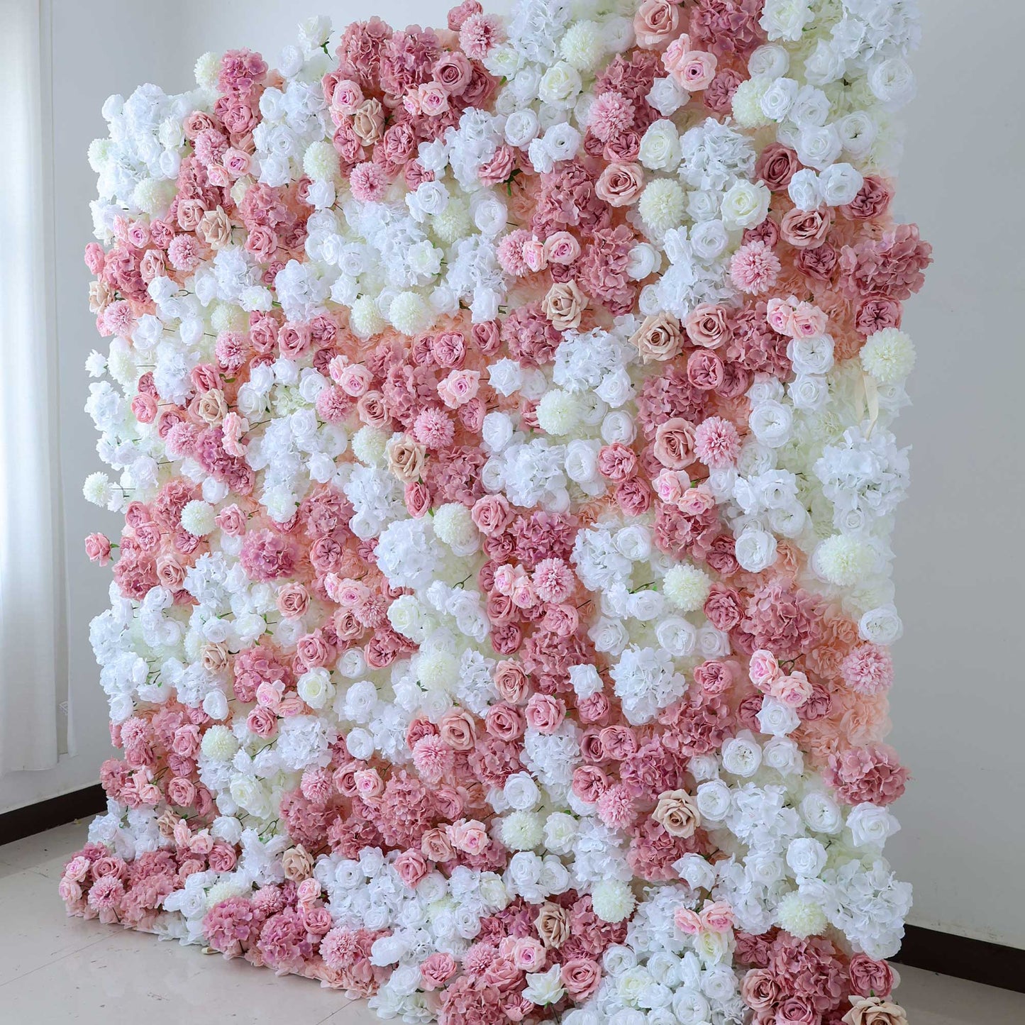 This floral wall showcases an array of white and pink roses, hydrangeas, and other blooms, creating a soft and romantic decorative display. 