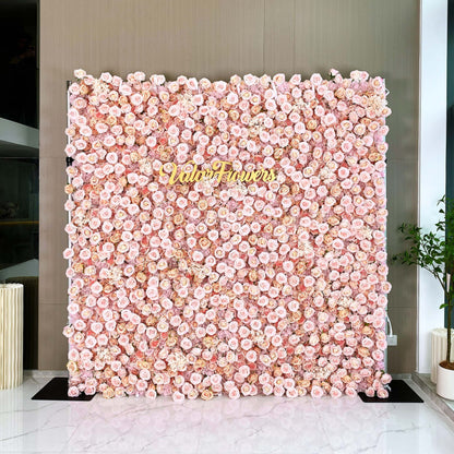 A large, square flower wall covered with an abundance of light pink roses. The text &quot;ValarFlowers&quot; is prominently displayed in the center, creating a romantic and elegant atmosphere.
