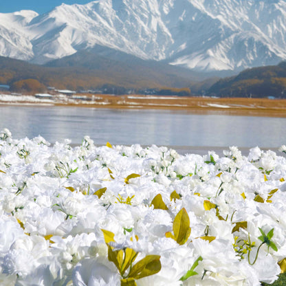 This backdrop features a profusion of artificial white flowers, including roses and other blooms, interspersed with green and golden - hued leaves. Set against a scenic view of mountains and a lake, it exudes elegance and natural beauty.

Ideal for outdoor weddings, it brings a touch of romance and purity. Also suitable for photo - shoots, corporate outdoor events, and nature - themed galas to enhance the aesthetic appeal. 