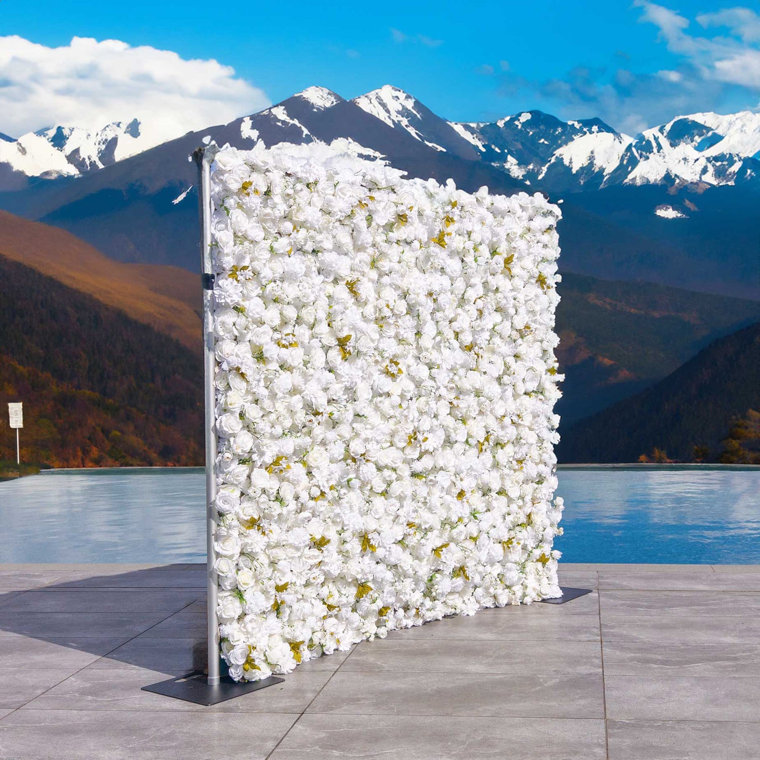 This backdrop consists of a metal - framed structure densely covered with artificial white flowers interspersed with some golden - hued leaves. Set against a scenic mountain and lake view, it exudes elegance and charm.

Ideal for outdoor weddings, it adds a touch of romance and purity. Also suitable for corporate events, photo shoots, and private parties, enhancing the aesthetic and creating a sophisticated atmosphere. 