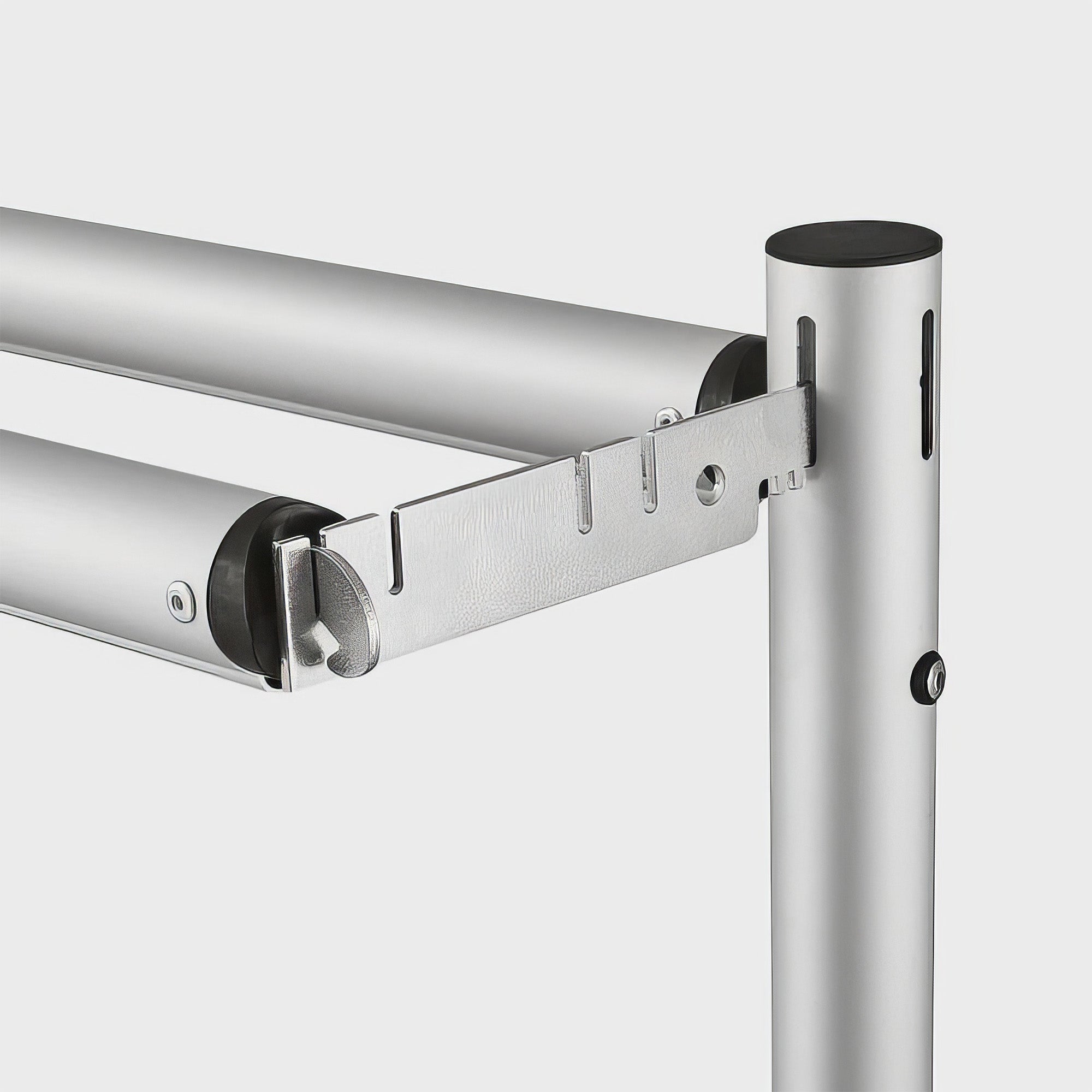 The image shows a close - up of a metal framework connection. Two horizontal poles attach to a vertical one via a metal bracket with holes and connectors, suggesting an adjustable and modular design. 