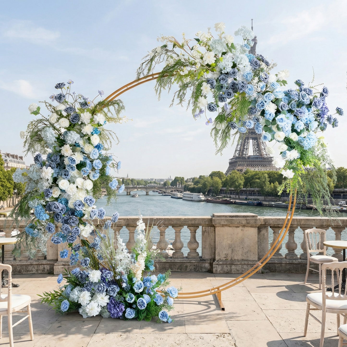 A sleek, gold circular floral arch from Valar Flowers, adorned with a serene palette of sky blue, navy, and creamy white blooms—including hydrangeas, roses, and delicate orchids—intertwined with cascading greenery. Set against the iconic Eiffel Tower and Seine River in Paris, it creates a sophisticated, romantic atmosphere perfect for a luxury wedding or special celebration.