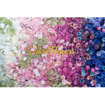 This photo showcases a lush floral arrangement with a gradient of white, pink, purple, and blue roses, along with hydrangeas and baby&