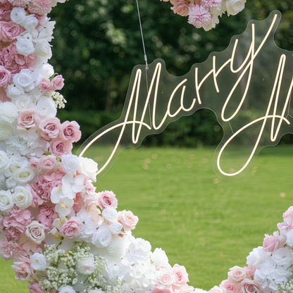 This close-up captures a romantic heart-shaped floral arch, crafted from a lush blend of blush pink, deep rose, and crisp white blooms—including roses, hydrangeas, orchids, and delicate baby&
