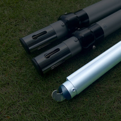The image displays three metal poles on a grassy background. Two poles have black connectors with rectangular cut - outs, while the third has a hooked end, indicating they could be parts of an adjustable setup. 