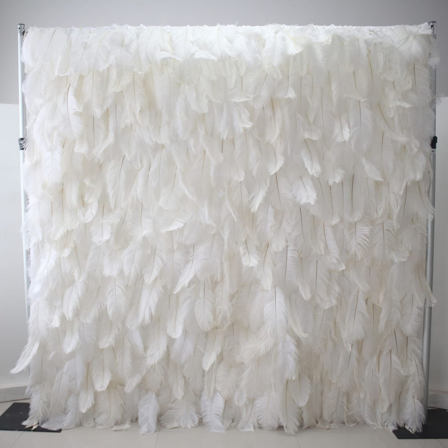 This image showcases a luxurious white feather backdrop by Valar Flowers. Densely packed with soft, pristine white feathers, it creates a plush, ethereal, and elegant display. The feathers' delicate texture and uniform white hue exude a sense of purity and sophistication, making it perfect for adding a touch of glamour to events or as a stunning decorative element, with the smooth, light - colored floor enhancing its refined appeal.