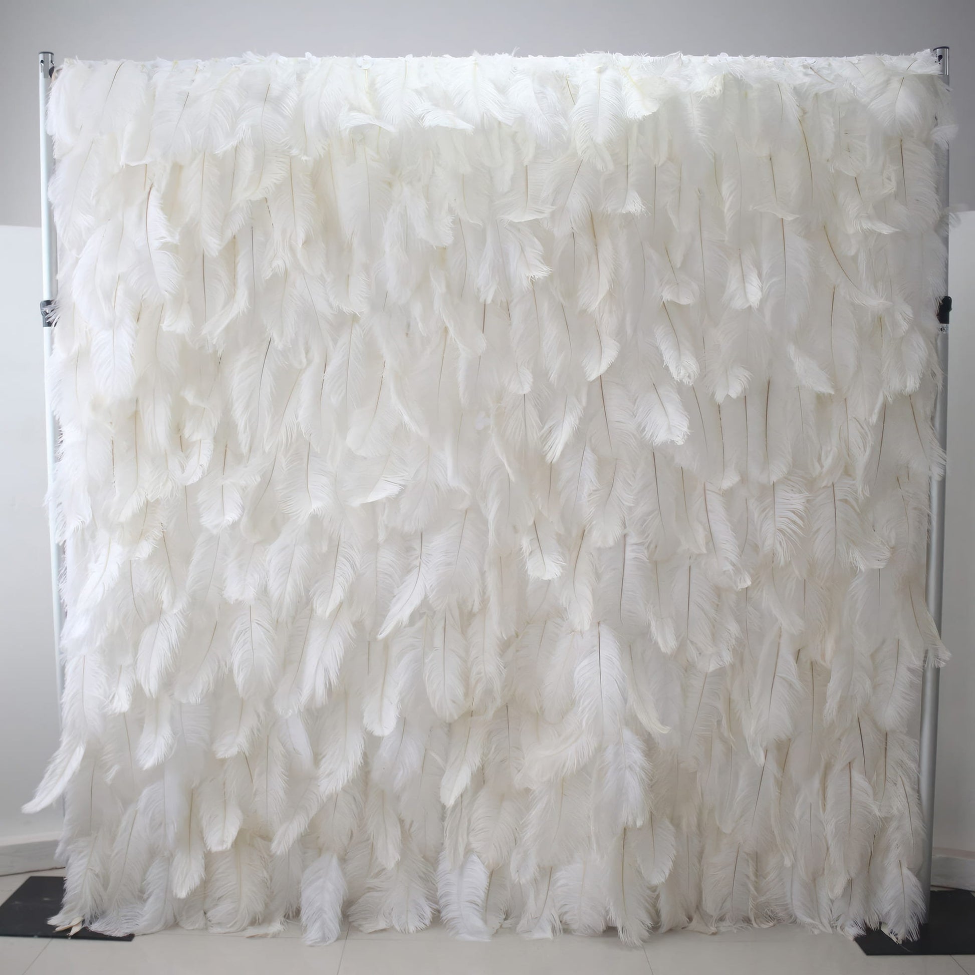 This image showcases a luxurious white feather backdrop by Valar Flowers. Densely packed with soft, pristine white feathers, it creates a plush, ethereal, and elegant display. The feathers' delicate texture and uniform white hue exude a sense of purity and sophistication, making it perfect for adding a touch of glamour to events or as a stunning decorative element, with the smooth, light - colored floor enhancing its refined appeal.