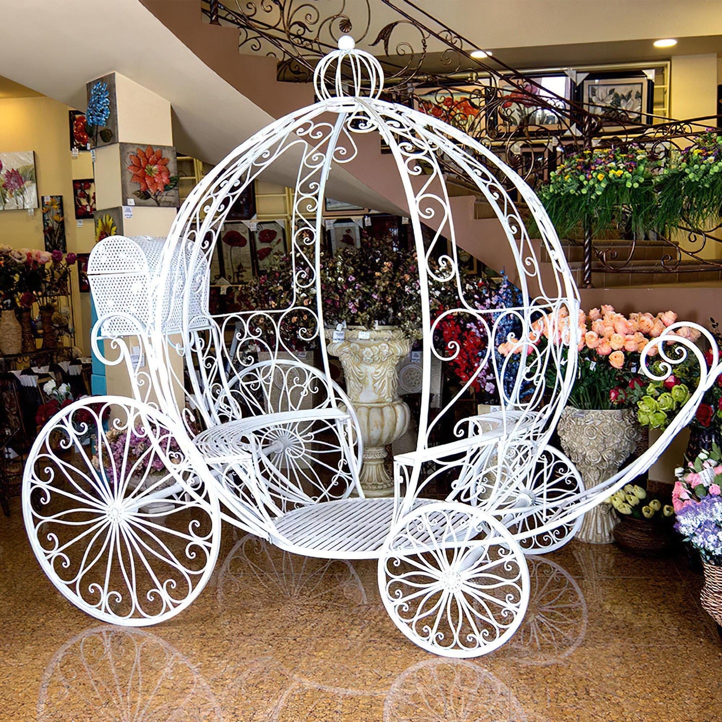 This elegant white wrought iron carriage by 'ValarFlowers' sits in a floral shop, surrounded by vibrant blooms. Often used for weddings, photo shoots, or themed events, it adds a magical, fairytale charm.