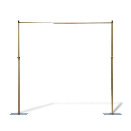 This image features an adjustable - size golden backdrop stand. It consists of two vertical poles connected by a horizontal bar at the top. The vertical poles have adjustable sections, indicated by the presence of connectors, which allow for height modification. The stand is supported by flat, rectangular base plates, providing stability. The golden finish gives it an elegant appearance, making it suitable for events like weddings or photography setups. 