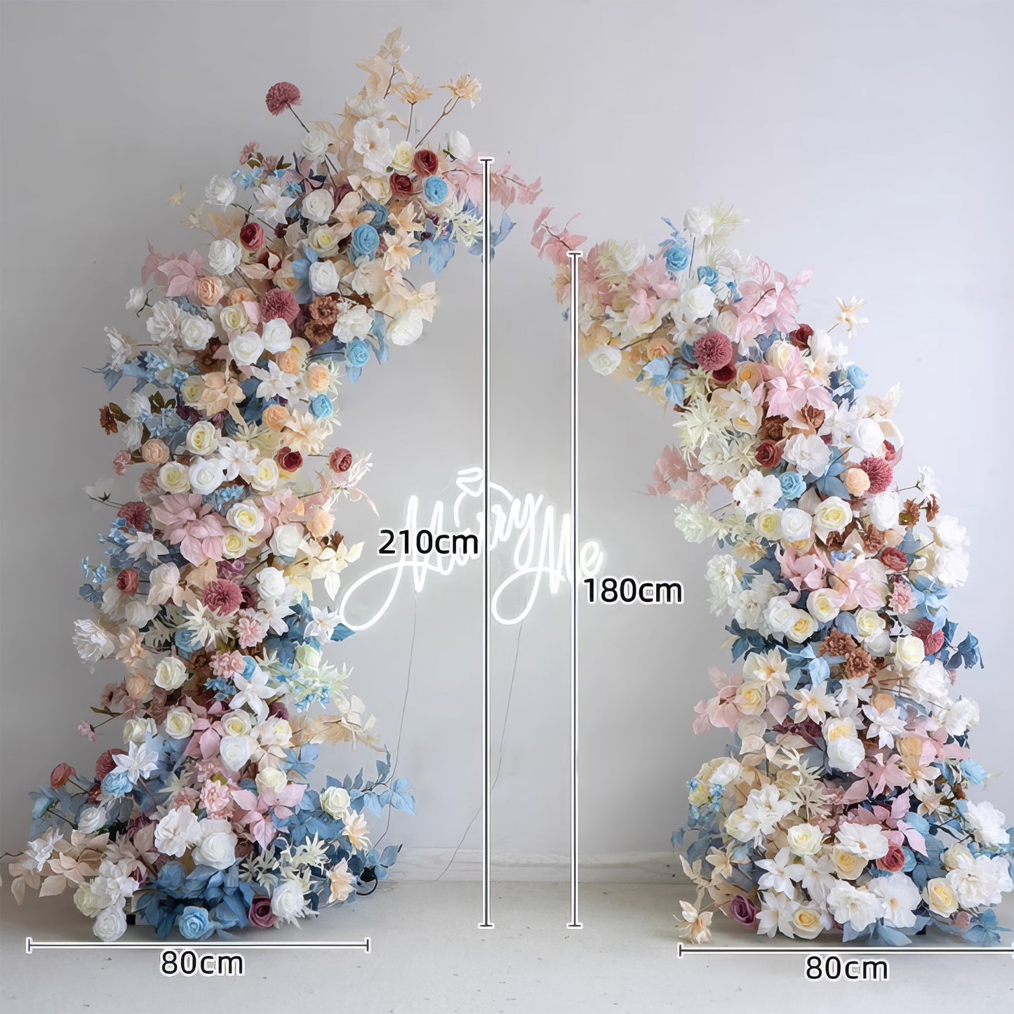 This flower - laden arch features a pastel palette of soft blues, pinks, whites, and muted earthy tones. Comprising roses, dahlias, and various blooms, it exudes a romantic, dreamy style. Measuring 210cm at the tallest part and 80cm at the base, it's perfect for weddings, events, and photoshoots.  