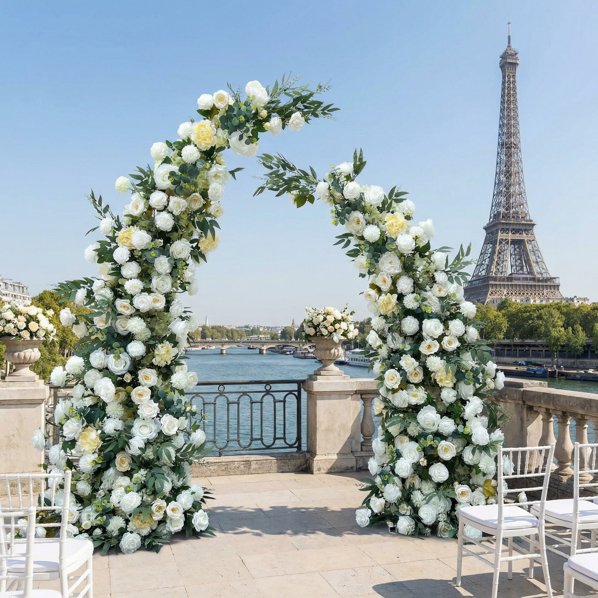 A timeless, asymmetrical floral arch from Valar Flowers, crafted with a fresh palette of pure white and soft cream blooms—including roses, peonies, and delicate foliage—intertwined with lush greenery. Set on a sunlit Parisian riverside terrace with the iconic Eiffel Tower in the background, it creates a serene, elegant, and ethereal atmosphere perfect for luxury weddings and refined photoshoots.