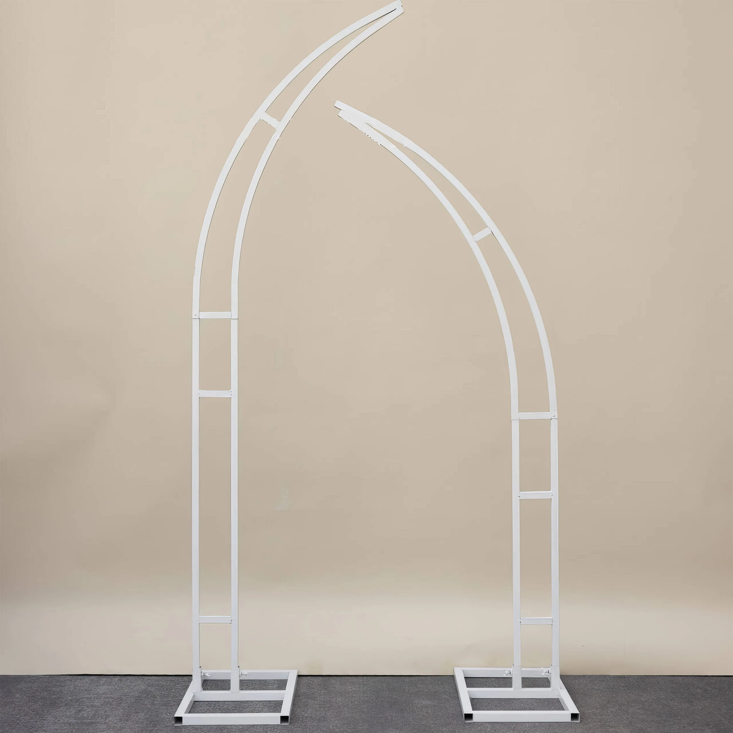 This is a minimalist white metal arch frame from Valar Flowers, featuring two curved, asymmetrical columns with square bases for stability. The sleek, modern design provides a versatile, sturdy structure ideal for draping with floral arrangements, fabric, or other decor, making it perfect for weddings, events, or photo backdrops.