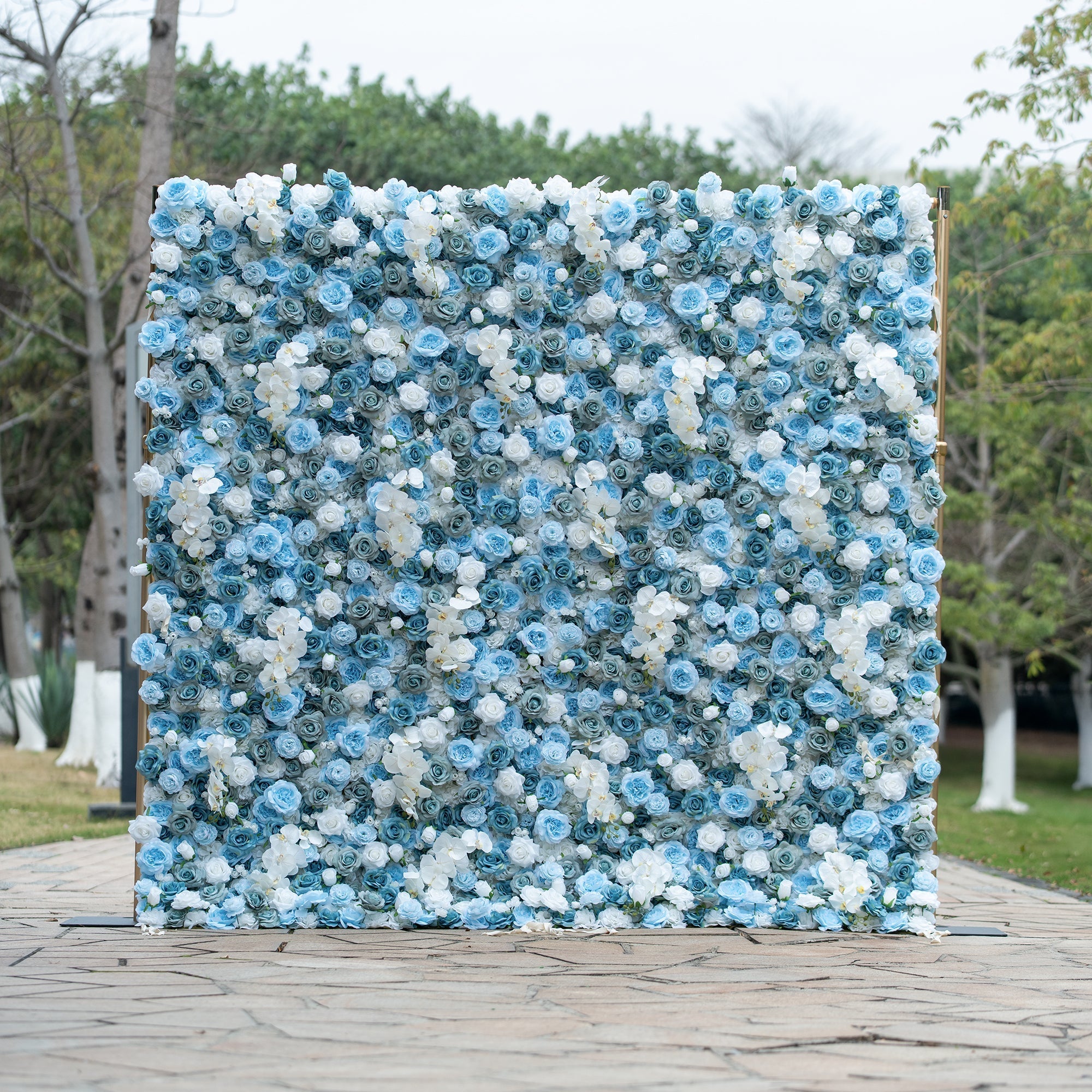 Valar Flowers blue and white artificial flower wall backdrop featuring a dense, lush arrangement of blue and white roses accented with elegant white orchids. This cool-toned floral display creates a serene and sophisticated backdrop ideal for weddings, events, and special occasions, bringing refined elegance to any celebration.